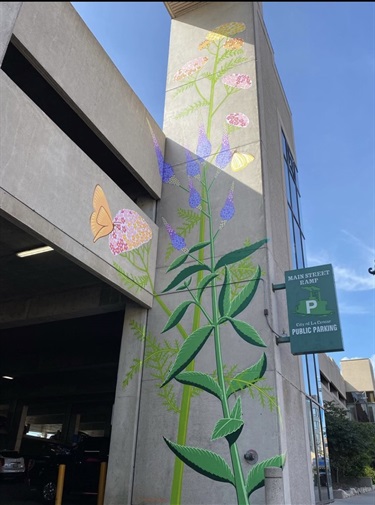 Mural of flowers and leaves painted on the side of a downtown building