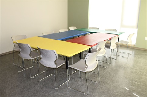 4 colored tables in a square showing setting up of room. tables are yellow, red, blue, and green. 