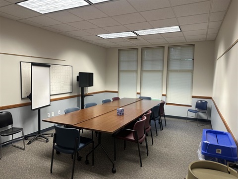 view of board room with tables set up in a square with chairs around the tables 