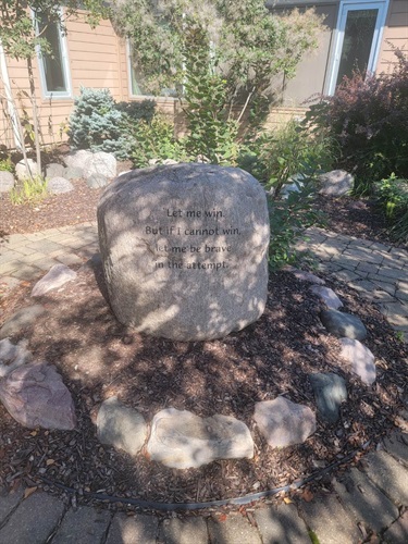 A large boulder engraved with the Special Olympics athlete oath 