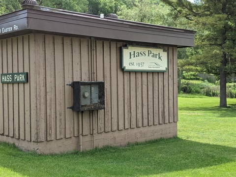 A brown wooden building with two signs that read 