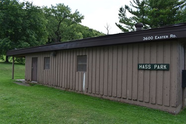 A brown wooden building with a dark brown roof labeled 