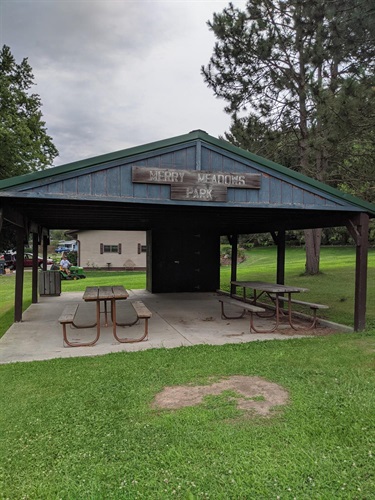 Merry Meadows Park pavilion with picnic tables and benches on a cloudy day.