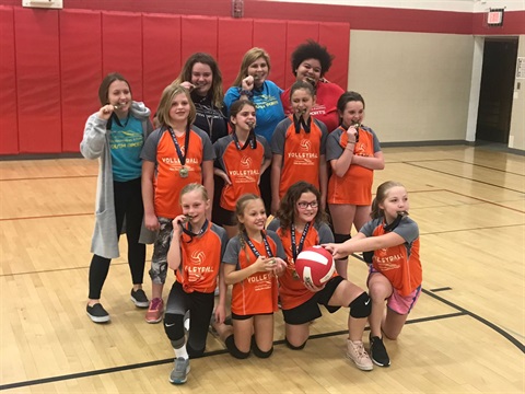 youth volleyball team posing with medals after tournament 