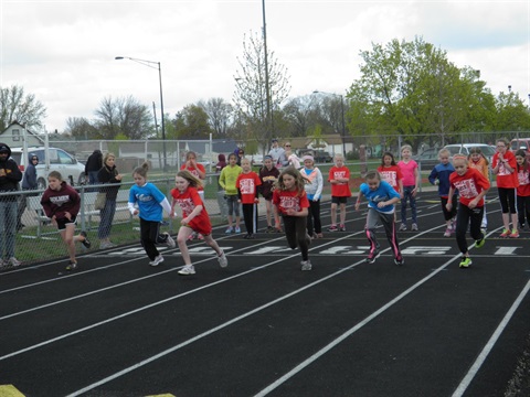 group of young track athletes that have just started a race on the track 