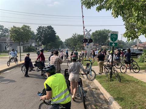 Participants in community bike ride stop at train tracks