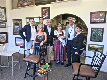 Group of people, some in traditional German dress, in a public meeting place