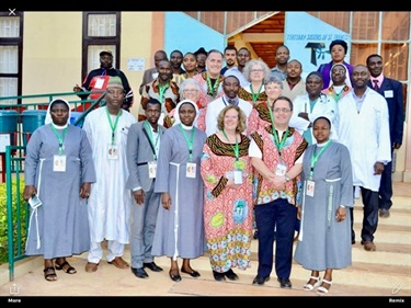 A group of nuns and other people standing on steps outside a church posing for a picture