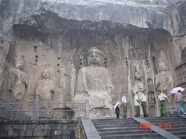 Tall statues of Buddha carved into a cave wall