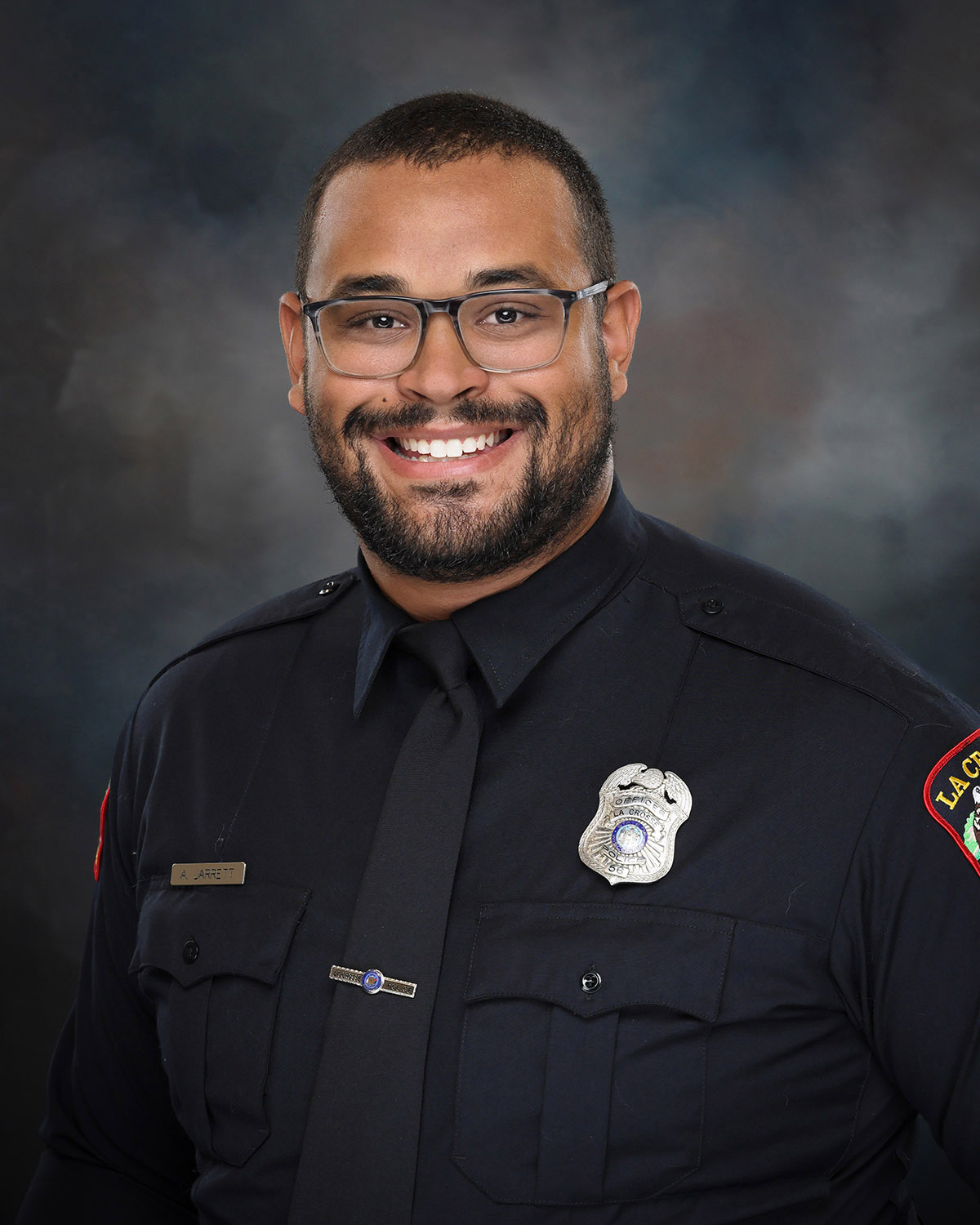 Professional portrait of a man in a police uniform.