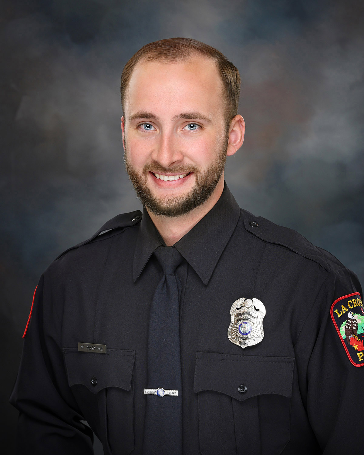 Professional portrait of a man in a police uniform.