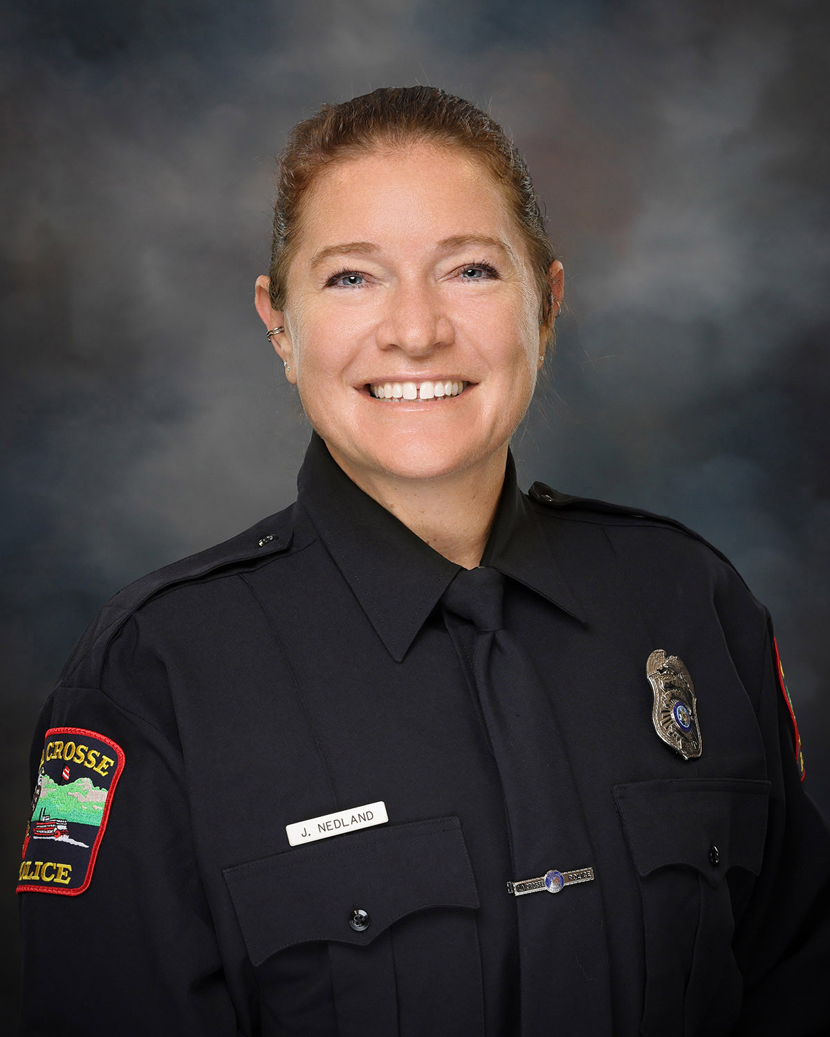 Professional portrait of a woman in a police uniform.