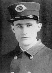A black and white photo of a young man in a police uniform from 1915.
